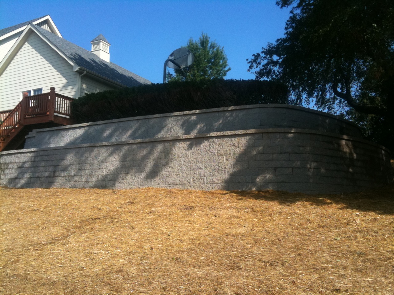 Excavator bucket dropping dirt into an open trench.
